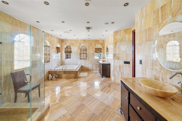 bathroom featuring tile flooring, separate shower and tub, vanity, and tile walls