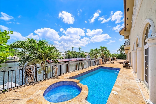 view of swimming pool with a patio, an in ground hot tub, and a water view