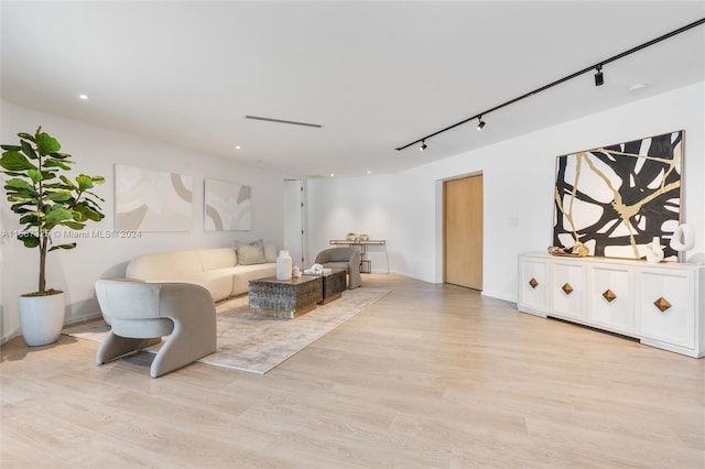 living room with rail lighting and light wood-type flooring