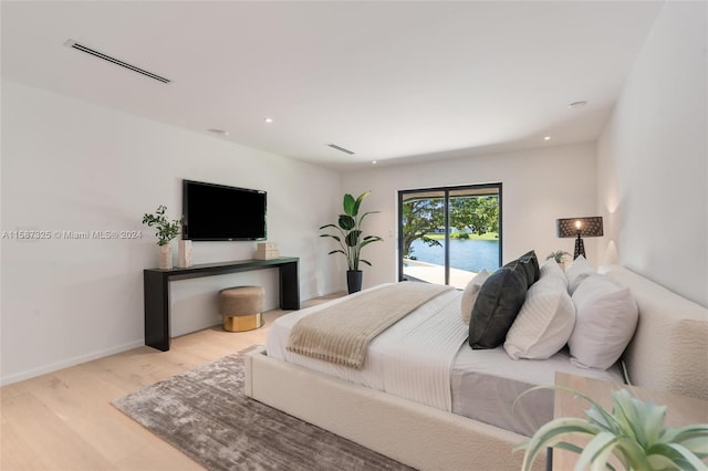 bedroom with access to outside and light wood-type flooring