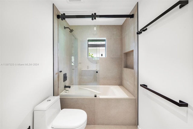 bathroom featuring combined bath / shower with glass door and toilet