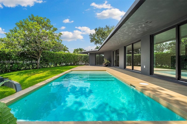 view of swimming pool with a yard