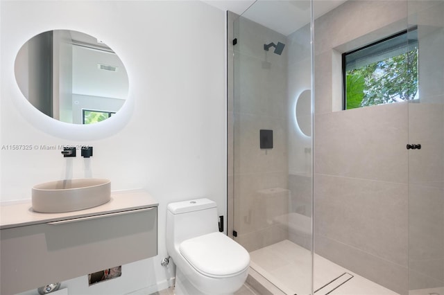 bathroom with vanity, a shower with door, and toilet