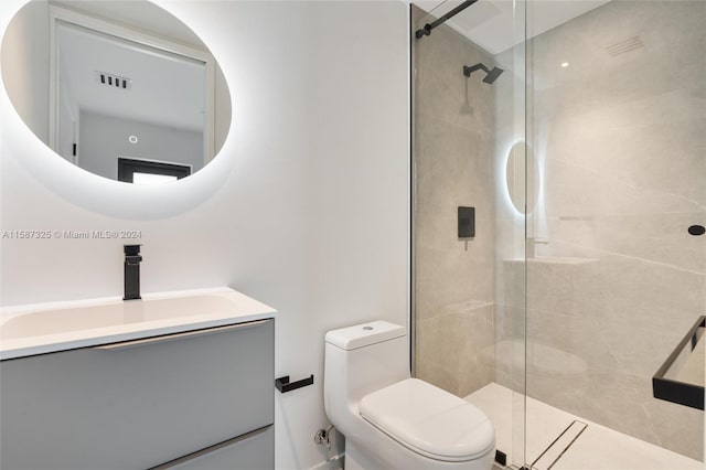 bathroom featuring an enclosed shower, vanity, and toilet