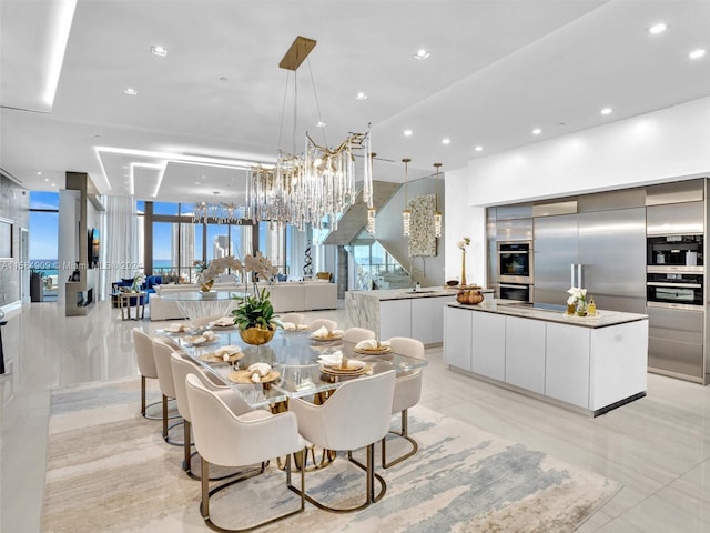 dining space featuring sink, an inviting chandelier, and light tile flooring