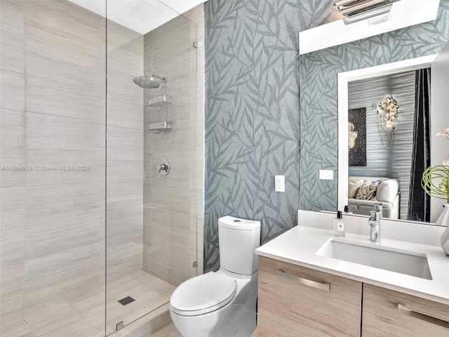 bathroom featuring tiled shower, toilet, and vanity