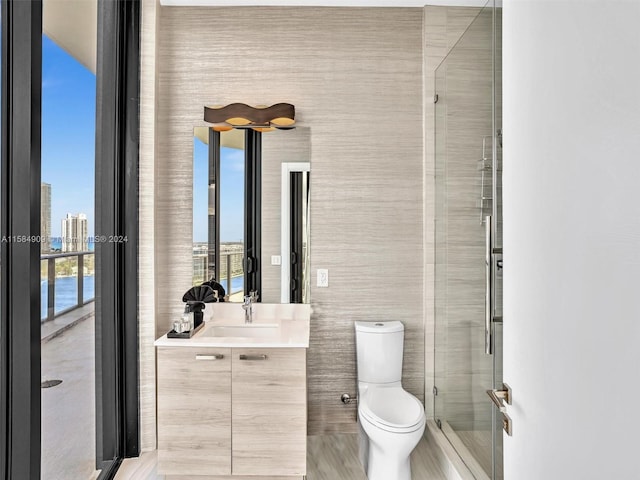 bathroom featuring walk in shower, oversized vanity, toilet, and tile walls