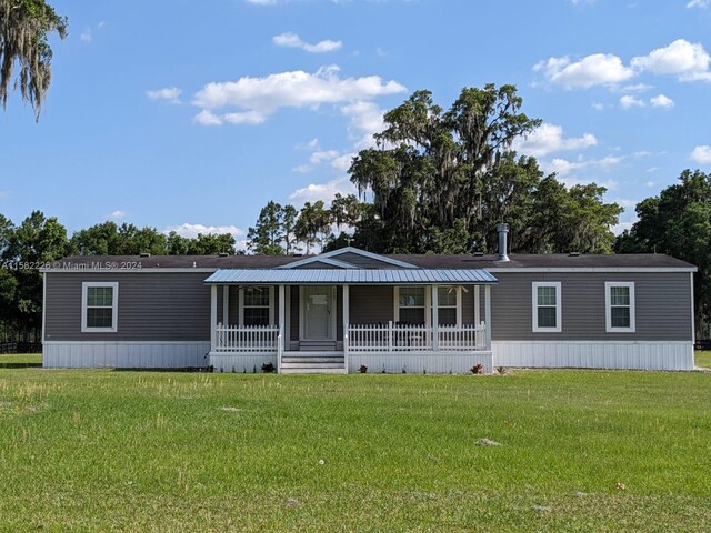 7787 NW 150th Ave, Ocala, FL 32668 - manufactured / mobile home with a porch and a front lawn