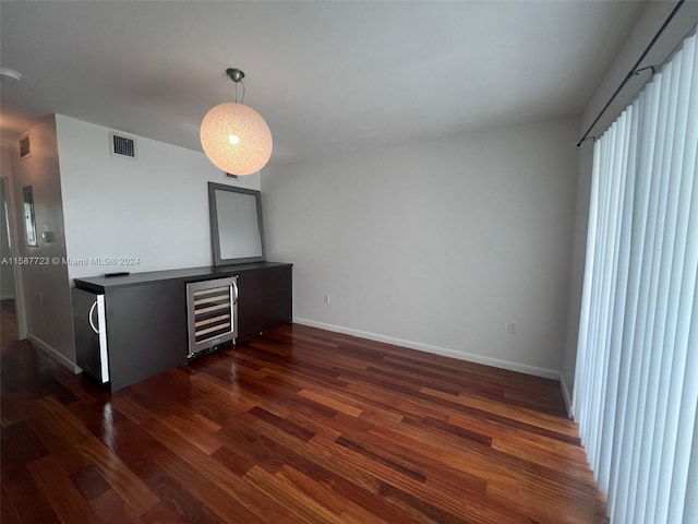 empty room featuring wine cooler and dark hardwood / wood-style floors