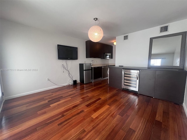 unfurnished living room featuring wine cooler and hardwood / wood-style floors