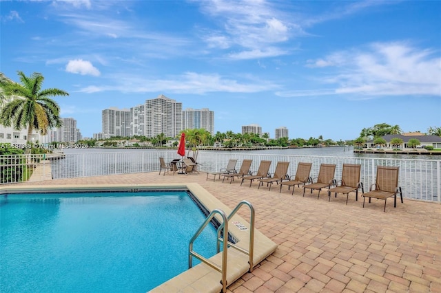 view of pool featuring a patio area and a water view