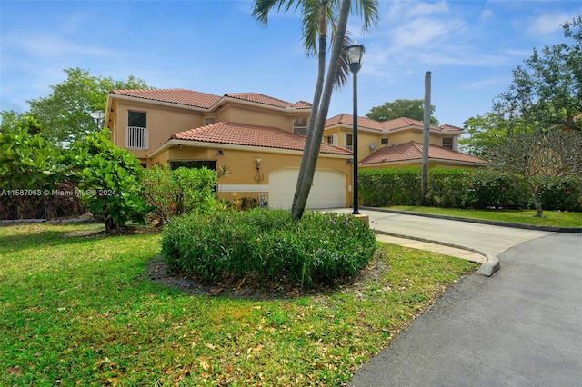 mediterranean / spanish home featuring a front lawn and a garage