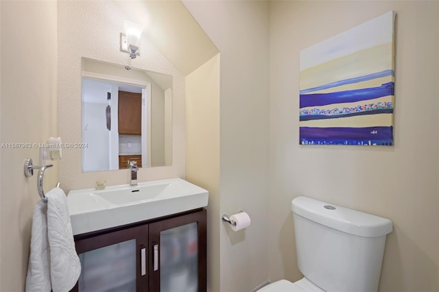 bathroom with tasteful backsplash, oversized vanity, and toilet