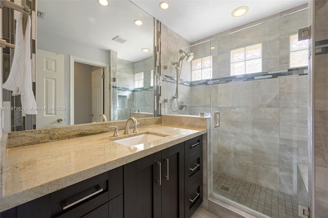 bathroom featuring walk in shower and vanity