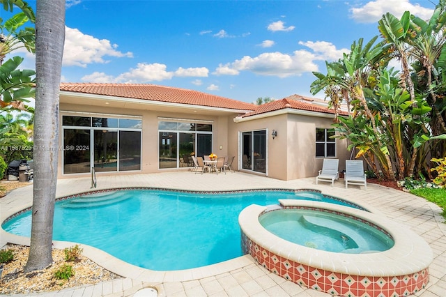 view of swimming pool with an in ground hot tub and a patio area