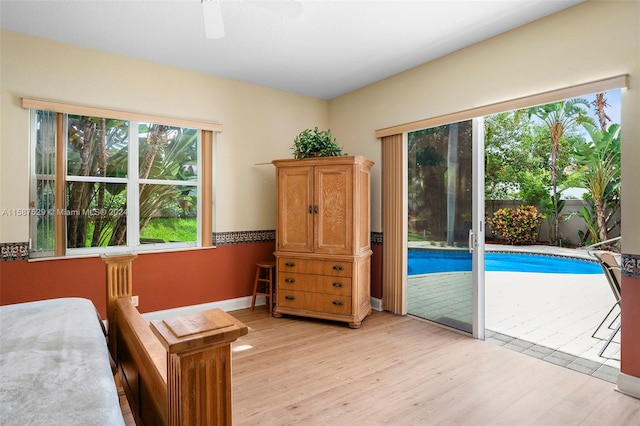 bedroom with access to outside, light wood-type flooring, and ceiling fan