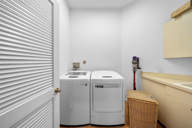 washroom featuring washing machine and dryer and cabinets