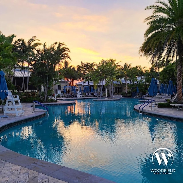 pool at dusk featuring a patio