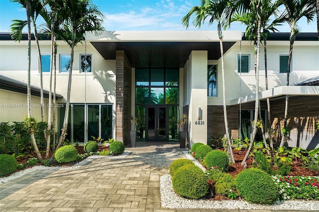 entrance to property featuring french doors and stucco siding
