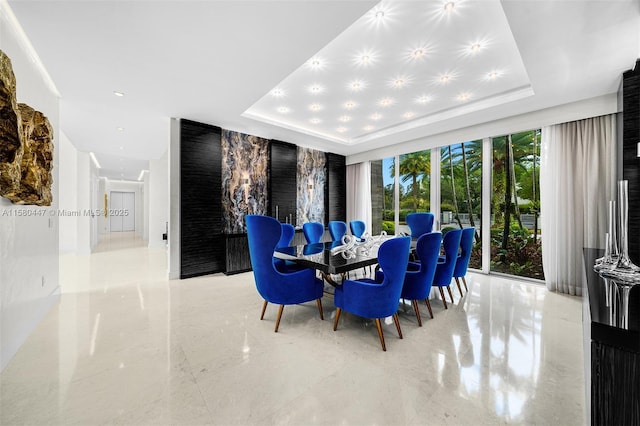 dining space with a raised ceiling and a wall of windows