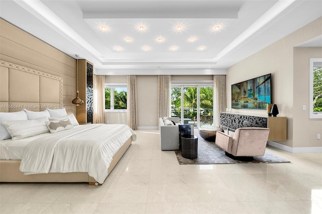 bedroom with a raised ceiling, multiple windows, and access to outside