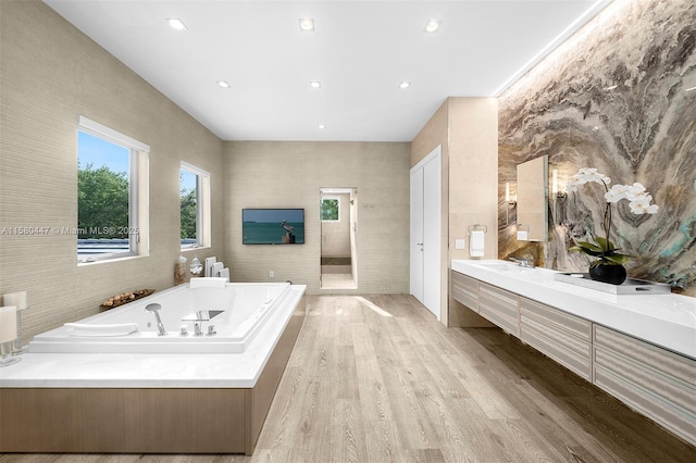 bathroom featuring vanity, a bath, and hardwood / wood-style flooring