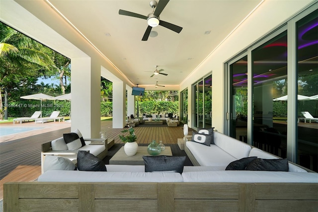 view of patio featuring ceiling fan, an outdoor living space, and a wooden deck