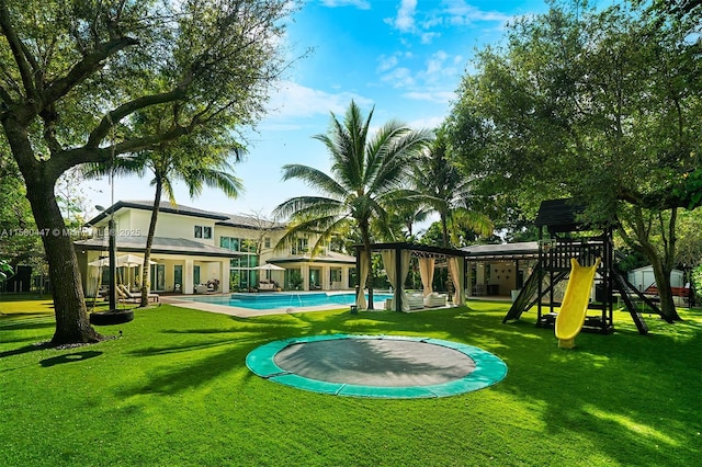 view of pool with a playground, a lawn, and a trampoline