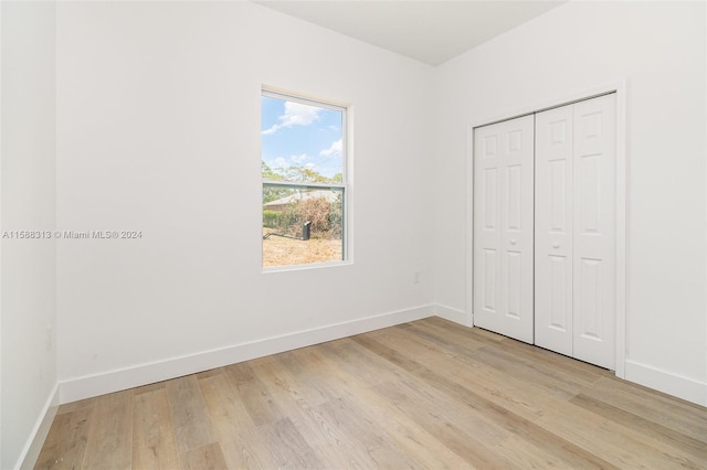 unfurnished bedroom featuring a closet and light hardwood / wood-style floors