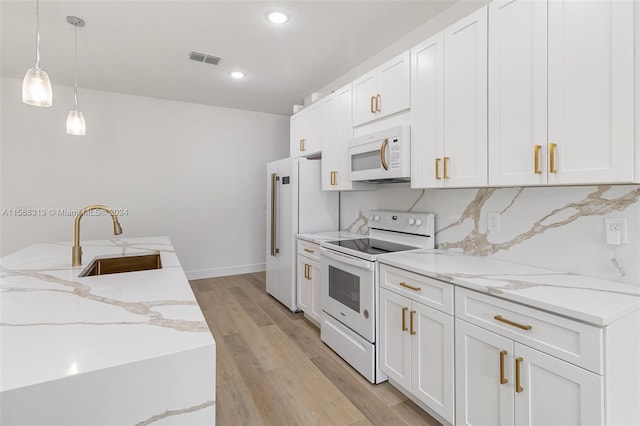 kitchen featuring white appliances, sink, pendant lighting, white cabinetry, and light hardwood / wood-style flooring