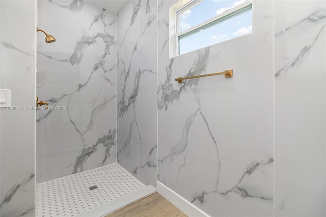 bathroom with wood-type flooring and tiled shower