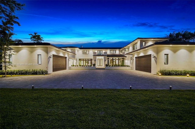 view of front of home featuring a garage and a yard