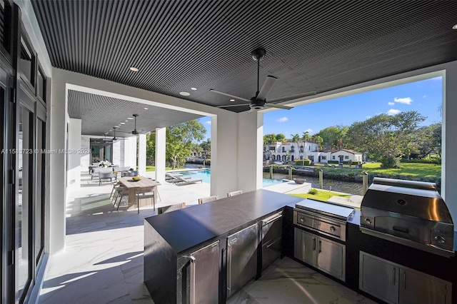 view of terrace with ceiling fan, an outdoor kitchen, and area for grilling