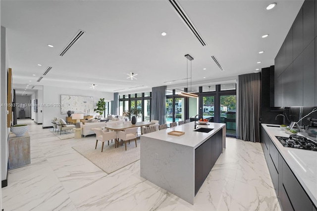 kitchen with a center island, hanging light fixtures, a wealth of natural light, sink, and light tile floors