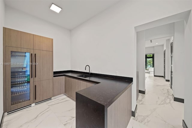 kitchen with dark stone countertops, sink, and light tile floors