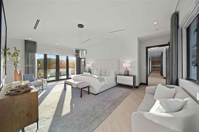 bedroom featuring access to outside, light hardwood / wood-style floors, french doors, and vaulted ceiling