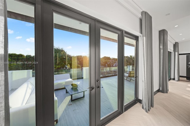 entryway with light parquet floors and french doors