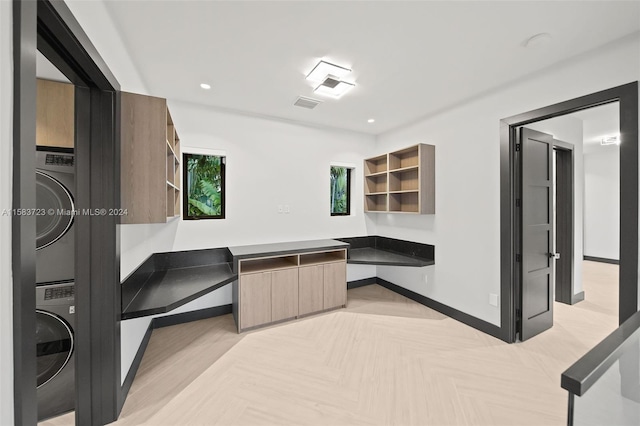 interior space with stacked washer and dryer and light parquet flooring