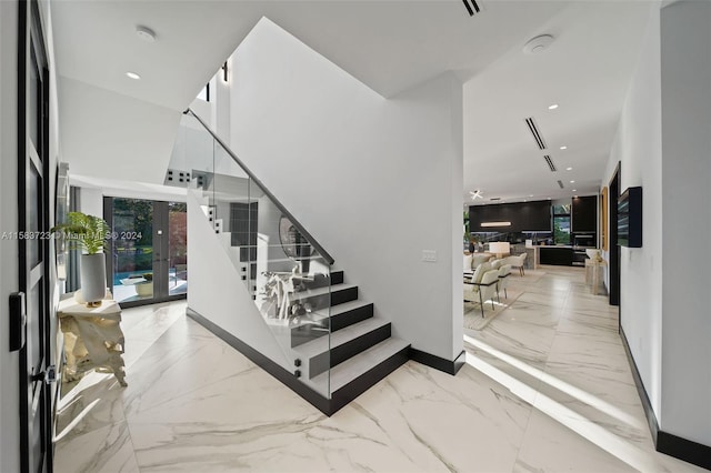 stairway featuring french doors and light tile floors