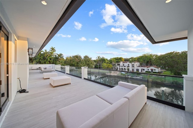 wooden deck with a water view and an outdoor hangout area