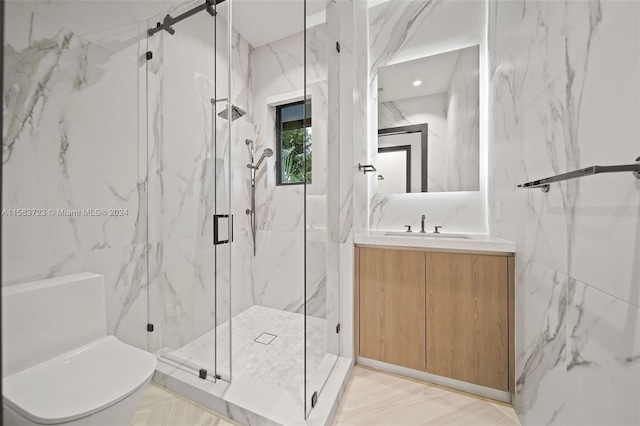 bathroom featuring a shower with shower door, tile walls, toilet, and large vanity