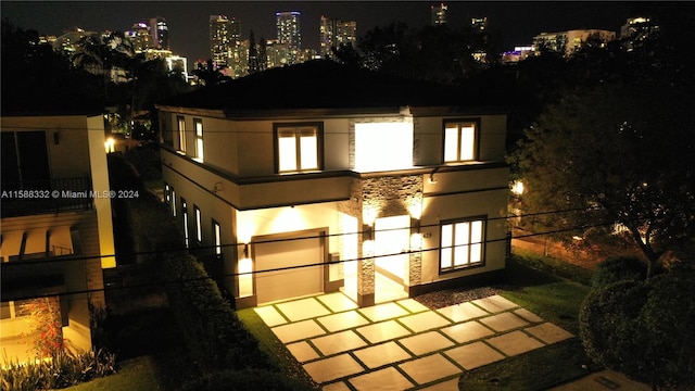 back house at twilight featuring a garage