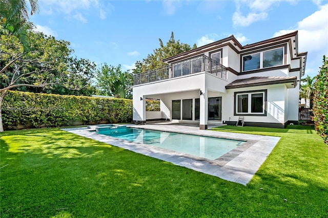 back of property with a balcony, a lawn, and a fenced in pool