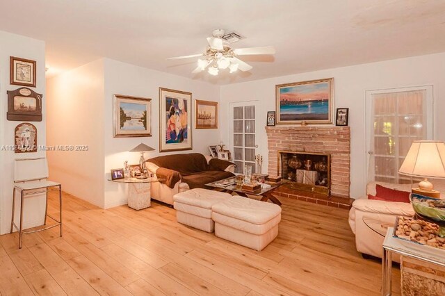 living room with ceiling fan, sink, and light wood-type flooring