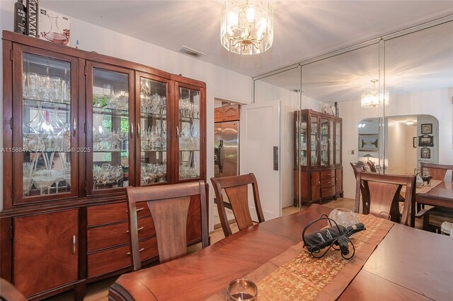 dining space featuring light hardwood / wood-style floors and a chandelier