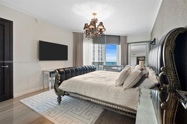 bedroom with light hardwood / wood-style floors, ornamental molding, and a notable chandelier