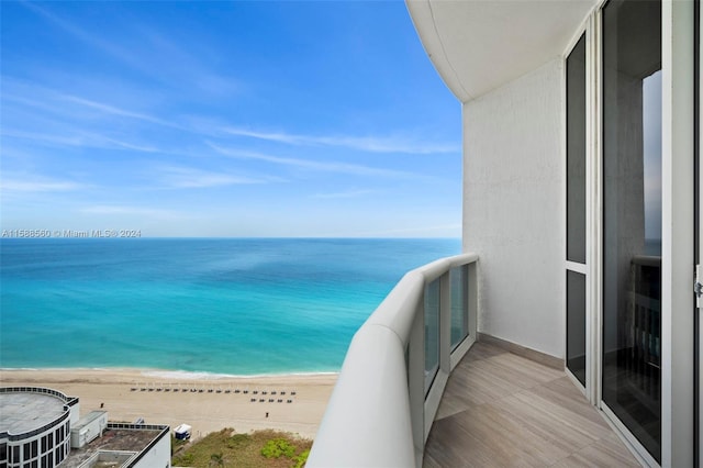 balcony featuring a beach view and a water view