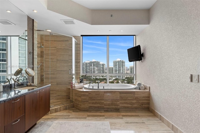 bathroom featuring separate shower and tub and vanity