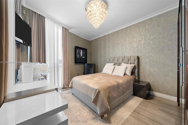 bedroom featuring light hardwood / wood-style floors, ornamental molding, and a chandelier