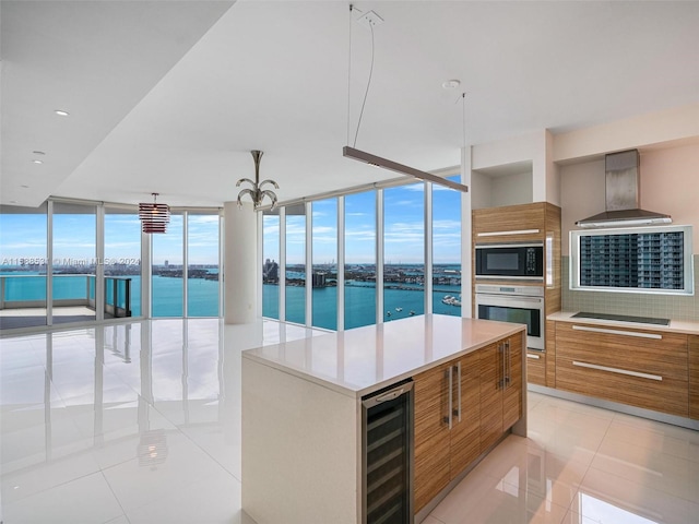 kitchen featuring wall chimney exhaust hood, wine cooler, black appliances, and a water view